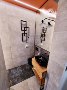 a bathroom with a sink and a counter with lights at Luksusowy Apartament Przy Sądzie Toruń in Toruń