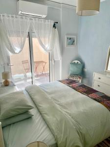 a bedroom with a bed and a large window at Socratous House in Salamís