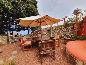 a wooden table and chairs with an umbrella at La Bodeguita Apartamento Santo Domingo in La Guancha