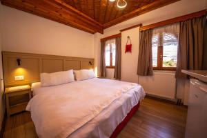 Un dormitorio con una gran cama blanca y una ventana. en Bed and Breakfast Kotoni, en Gjirokastra