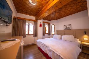 a bedroom with a large white bed in a room at Bed and Breakfast Kotoni in Gjirokastër