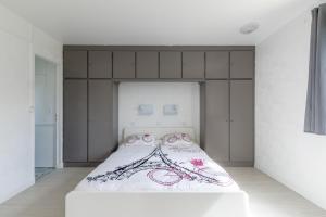 ein Schlafzimmer mit einem großen weißen Bett mit rosa Akzenten in der Unterkunft La maison des dunes - Proche plage pour 6 in Courseulles-sur-Mer
