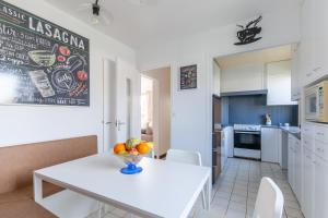 eine Küche mit einem Tisch und einer Obstschale darauf in der Unterkunft La maison des dunes - Proche plage pour 6 in Courseulles-sur-Mer