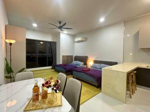 een woonkamer met 2 bedden en een tafel en een keuken bij Danga Bay 4pax Highest floor Nice View in Johor Bahru