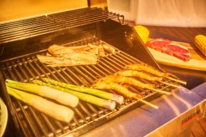 a grill with meat and vegetables on it at 隠れ家リゾート/アウトドアステイホテル/HERMiT ichinomiya【ハーミットいちのみや】 in Ichinomiya