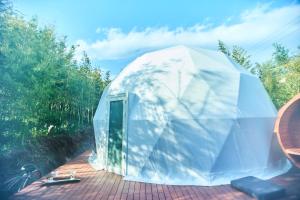 a white dome tent sitting on a patio at 隠れ家リゾート/アウトドアステイホテル/HERMiT ichinomiya【ハーミットいちのみや】 in Ichinomiya