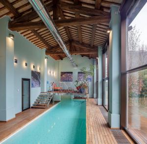 an indoor swimming pool with a wooden ceiling and a large window at Casa Laderchi in Prada