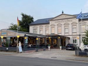 un grand bâtiment blanc sur le côté d'une rue dans l'établissement Hotel Restaurant Hellas, à Gelting