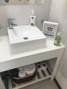 uma casa de banho com um lavatório branco e alguns produtos de higiene pessoal em CALMA em La Rioja