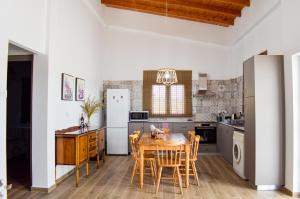 a kitchen with a table and chairs and a refrigerator at Galatia's House in Kouklia