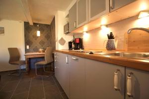 eine Küche mit einer Spüle und einer Theke mit Stühlen in der Unterkunft Hof Seebrookquelle in Schlesen