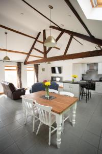 a kitchen and living room with a wooden table and chairs at 1 Beacon View Barn in Felindre