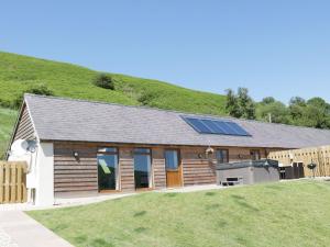 una casa con pannelli solari in cima a una collina di 1 Beacon View Barn a Felindre