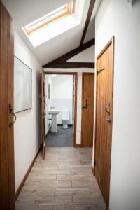 a hallway with a bathroom with a toilet and a skylight at 1 Beacon View Barn in Felindre