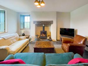 a living room with a couch and a fireplace at Coed Mawr in Betws-y-coed
