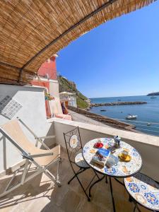 a table and chairs on a balcony with a view of the ocean at Calilla house by Procida Reserve in Procida +22 photos