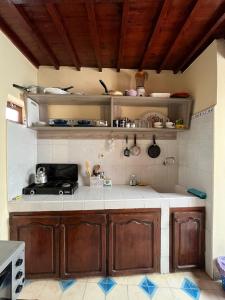 uma cozinha com armários de madeira e bancadas brancas em zazou em Essaouira