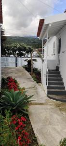 a white house with stairs and flowers in front of it at Casa da Avó Biza in São Roque do Pico