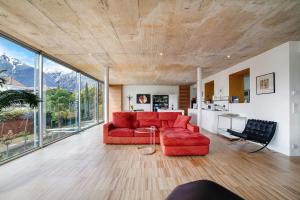 ein Wohnzimmer mit einem roten Sofa und einem Tisch in der Unterkunft Villa Alvarium 2 in Schenna