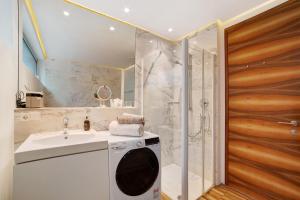 y baño con lavadora y ducha. en Villa Alvarium 2, en Scena 20 fotos más