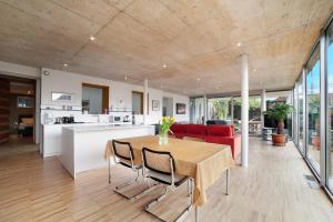 Una cocina y una sala de estar con mesa y sillas. en Villa Alvarium 2, en Scena
