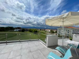 a patio with chairs and an umbrella on a roof at Breathtaking View design apartment in Katerini