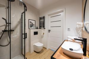 ein Badezimmer mit Dusche, Toilette und Waschbecken in der Unterkunft Apartament Mglisty Poranek - Laguna Beskidów - Dream Apart in Zarzecze + 25 Fotos