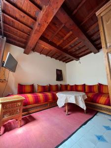 una sala de estar con sofás rojos y una mesa. en zazou en Essaouira