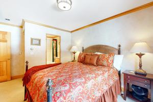 a bedroom with a large bed and two lamps at The Village Glen in Vail