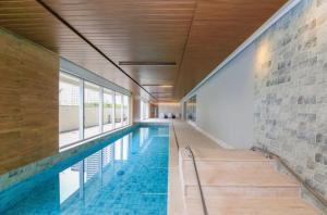 a swimming pool in a building with a brick wall at Apartamento luxo próximo Alphaville com vaga -5 min estação trem -ótima localização in Osasco