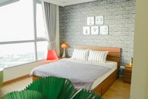 1 dormitorio con cama y pared de ladrillo en Liam Service Apartment - Vinhome Central Park en Ho Chi Minh