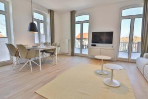 a living room with a table and a tv at Lüttjeod - Apartment 13 in Langeoog