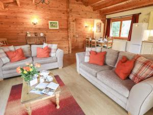 a living room with two couches and a table at Teal Lodge in Market Rasen