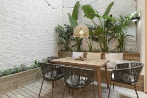 una mesa de madera y sillas en una habitación con plantas en Ola Living Calabria, en Barcelona