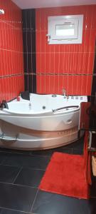 a red tiled bathroom with a tub and a red rug at Casa Pepe in Meaño