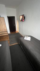 a room with a bed and a flat screen tv at Pension Chevermeto in Chemnitz