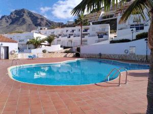 een zwembad in een resort met een berg op de achtergrond bij Apartamento Vista Atlántico in Adeje