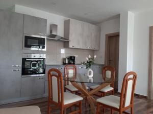 een keuken met een tafel en stoelen en een keuken met een fornuis bij Apartments Tea and Tamara in Pirovac