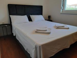 duże białe łóżko z dwoma ręcznikami w obiekcie Apartments Tea and Tamara w mieście Pirovac