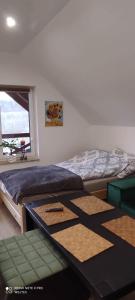 a bedroom with a bed and a table and a window at Gajówka Świt in Łyskowo