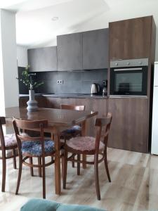 a kitchen with a wooden table and chairs at Apartments Tea and Tamara in Pirovac