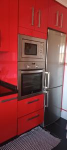 a kitchen with red cabinets and a stainless steel oven at Casa Pepe in Meaño