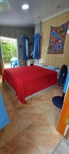 a bedroom with a large bed with a red blanket at chambre indépendante chez l'habitant in Parrita +62 photos