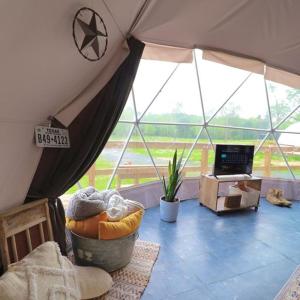 une chambre avec une tente dotée de fenêtres et d'une télévision dans l'établissement The Pines, Glamping Dome, 