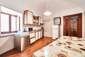 a kitchen with a table and a refrigerator at Appartamento Ilaria in Villa Laura in Scala