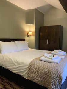 um quarto de hotel com uma cama com toalhas em George and Dragon em Tarvin