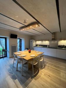 a large kitchen with a wooden table and chairs at Spacious town house in the center of le Bourg d'Oisans in Le Bourg-dʼOisans