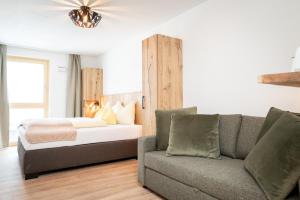 a living room with a bed and a couch at Wildbach Lodge Dienten in Dienten am Hochkönig