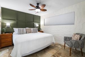 a bedroom with a white bed and a ceiling fan at Casa De Emdeko 104 in Kailua-Kona