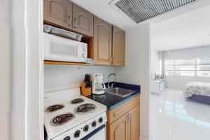 a kitchen with a stove and a microwave at Decoplage Paradise - Unit A in Miami Beach